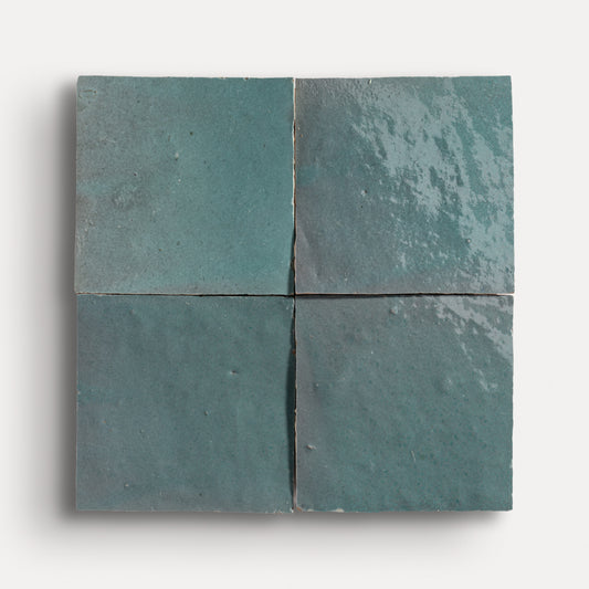 Four square zellige teal tiles arranged in a grid pattern on a white background