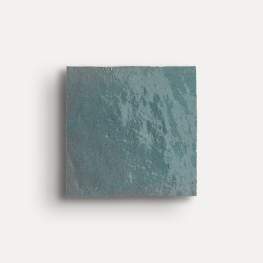 Square teal zellige tile on a white background