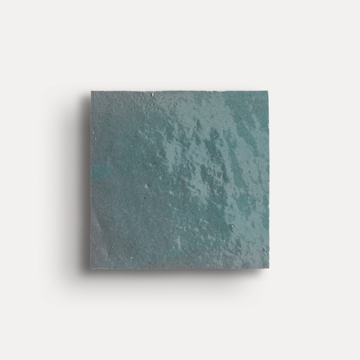 Square teal zellige tile on a white background