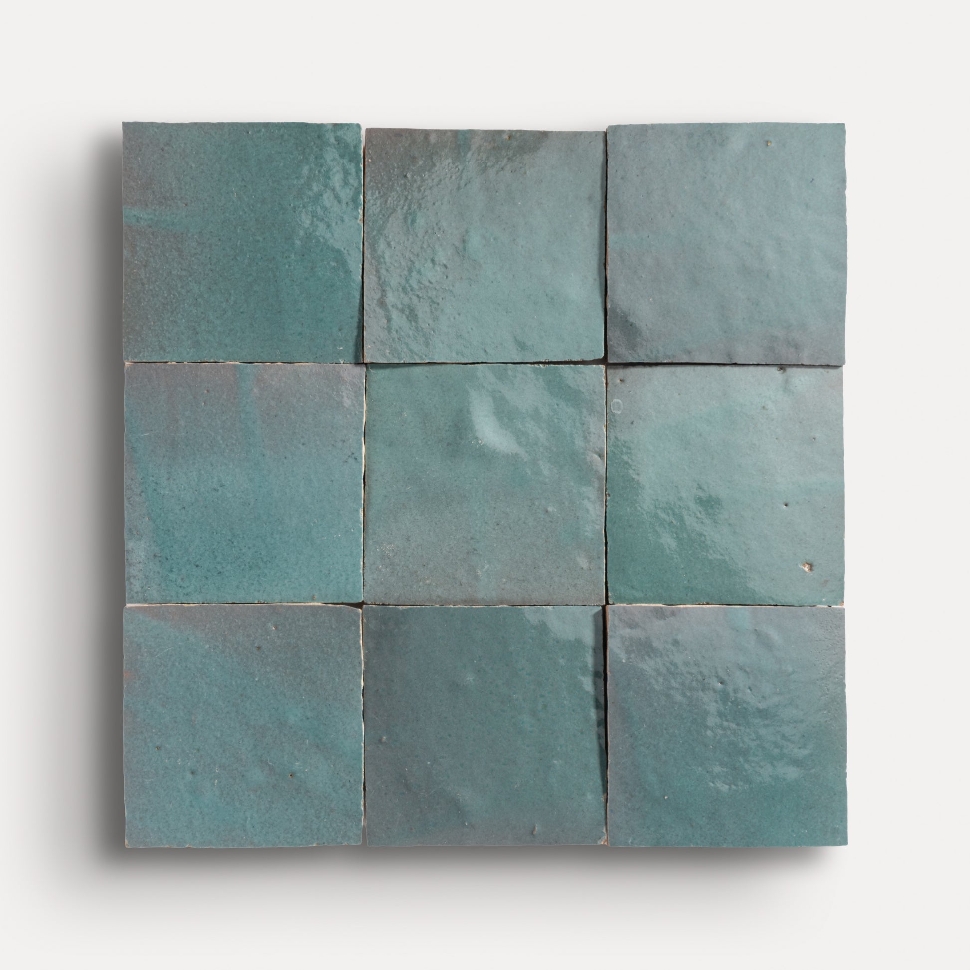 Nine square teal zellige tiles arranged in a grid pattern on a white background