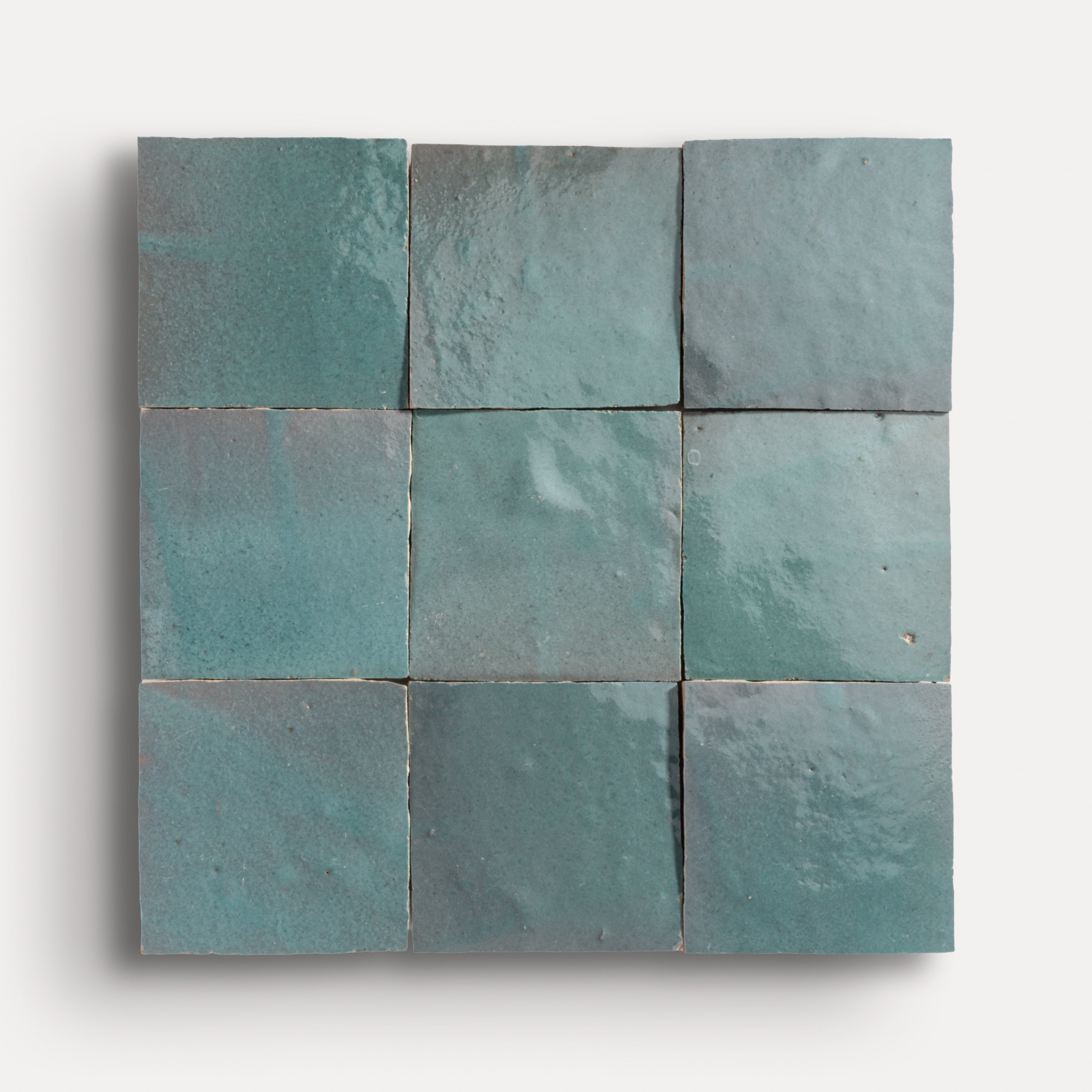 Nine square teal zellige tiles arranged in a grid pattern on a white background