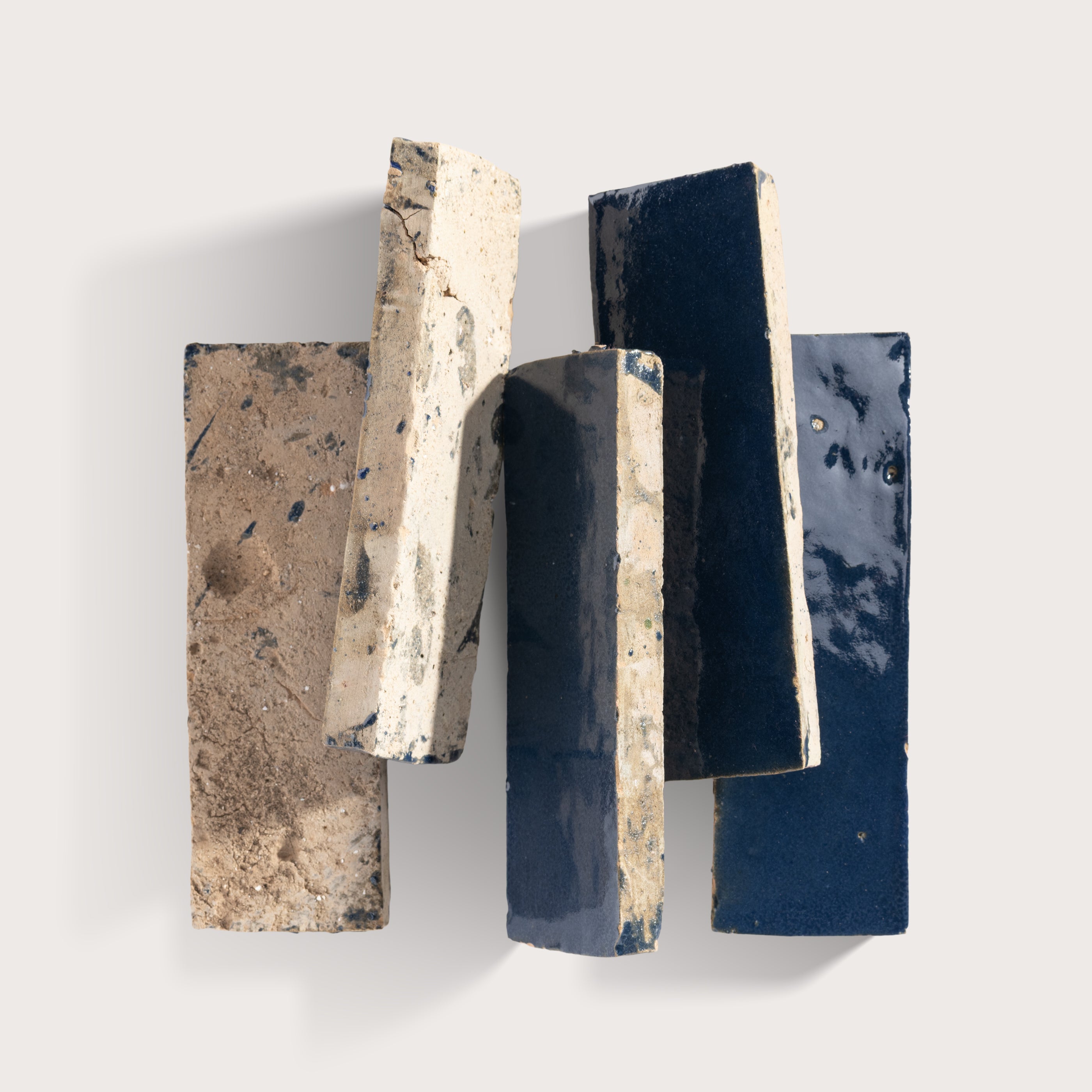 Set of five rectangular stone tiles with varying textures and colors on a light gray background