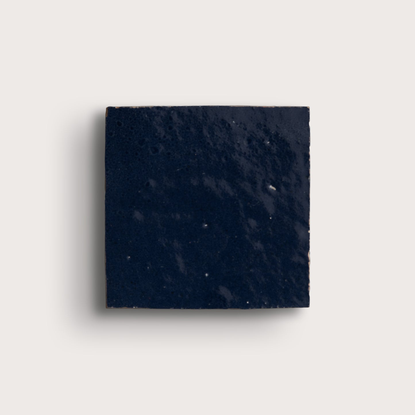 Square piece of dark blue stone on a light gray background