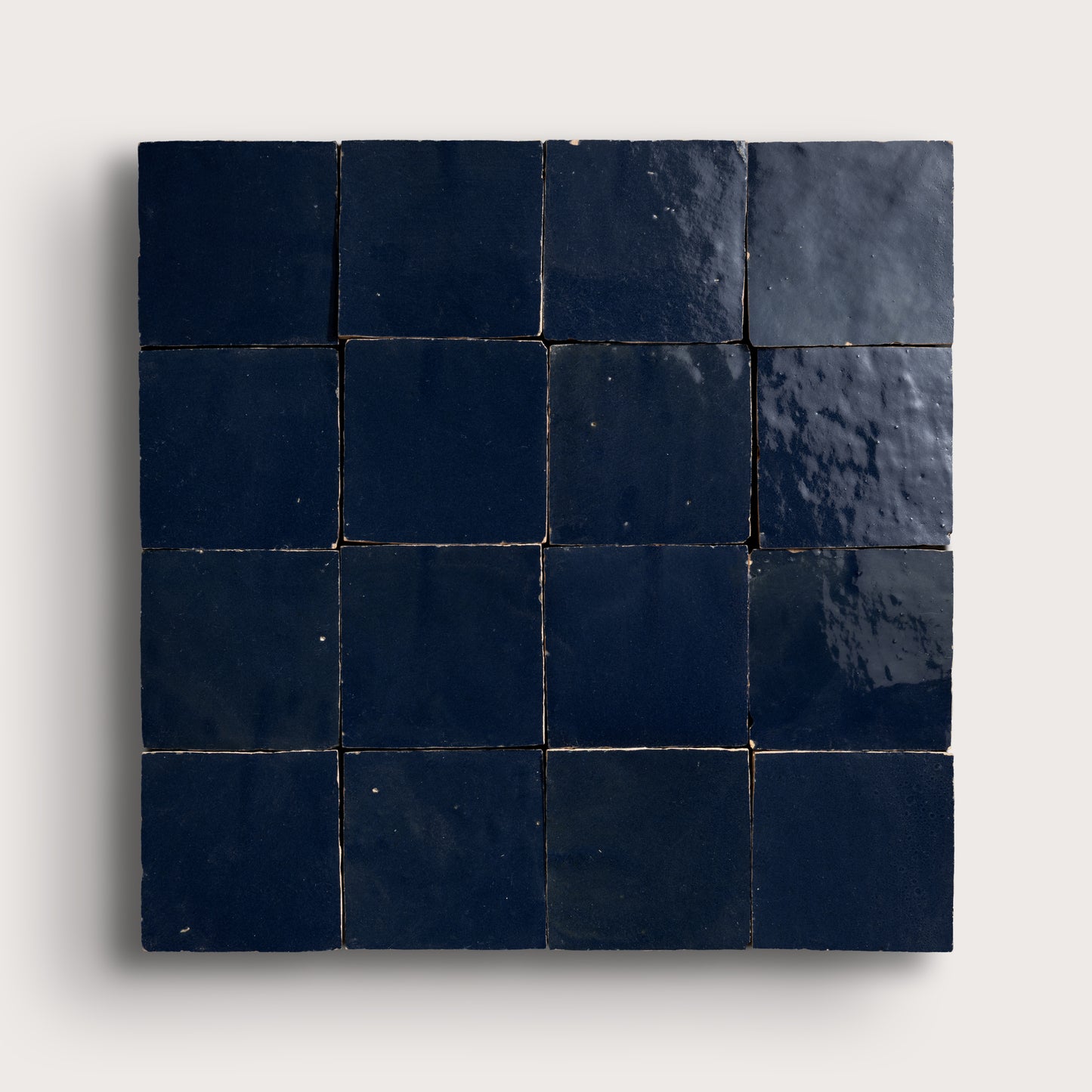 Square zellige tile with dark blue tiles on a light gray background