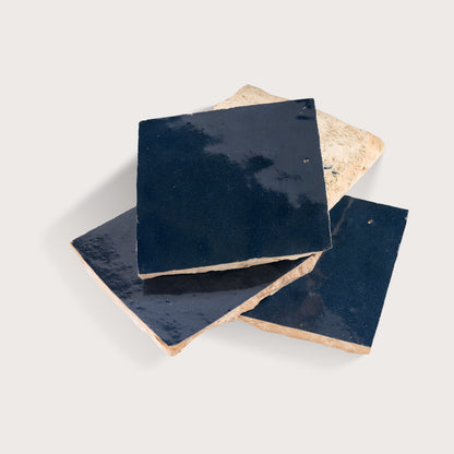 Set of square tiles with dark blue surface and beige edges on a light gray background