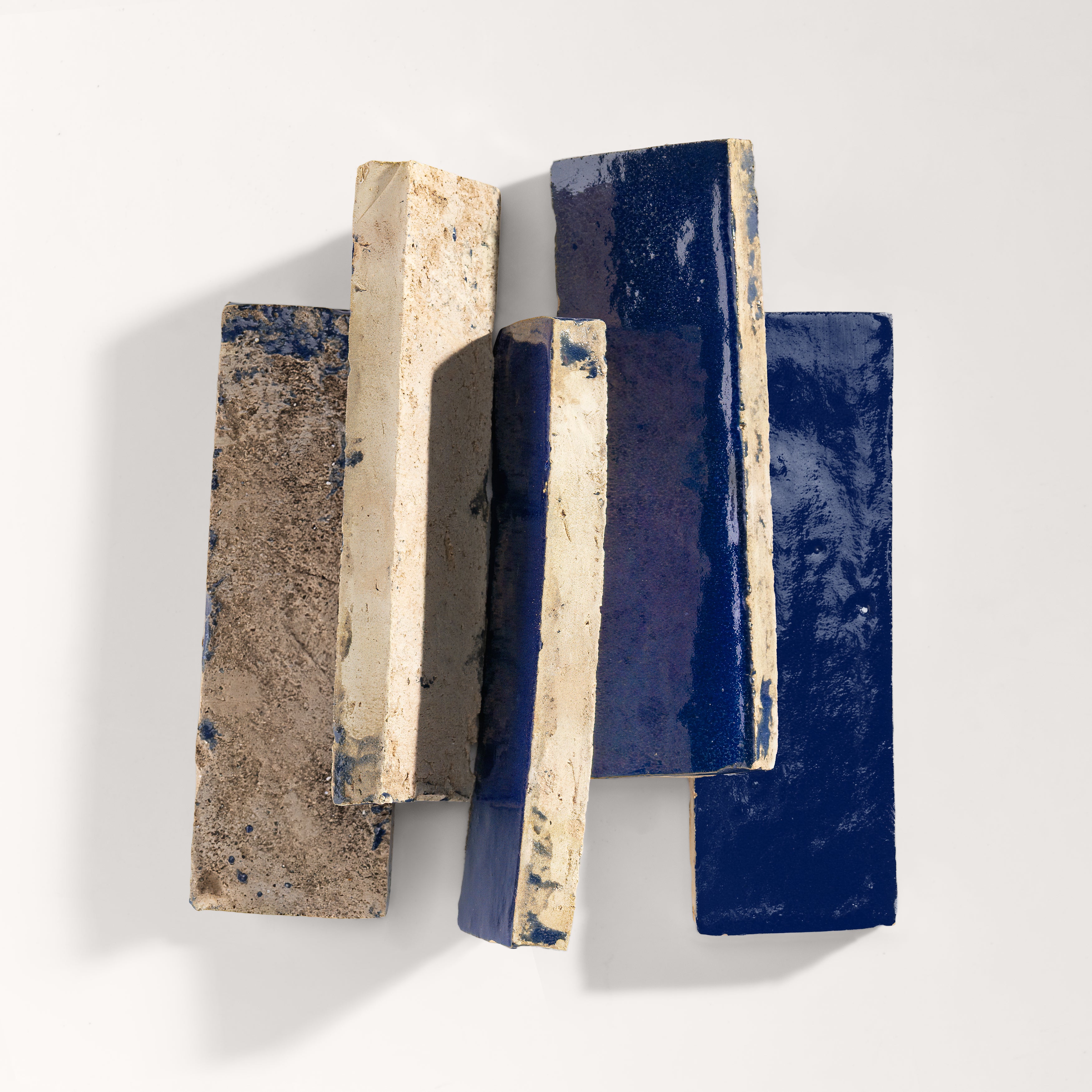 stack of blue rectangle zellige tile on light grey background