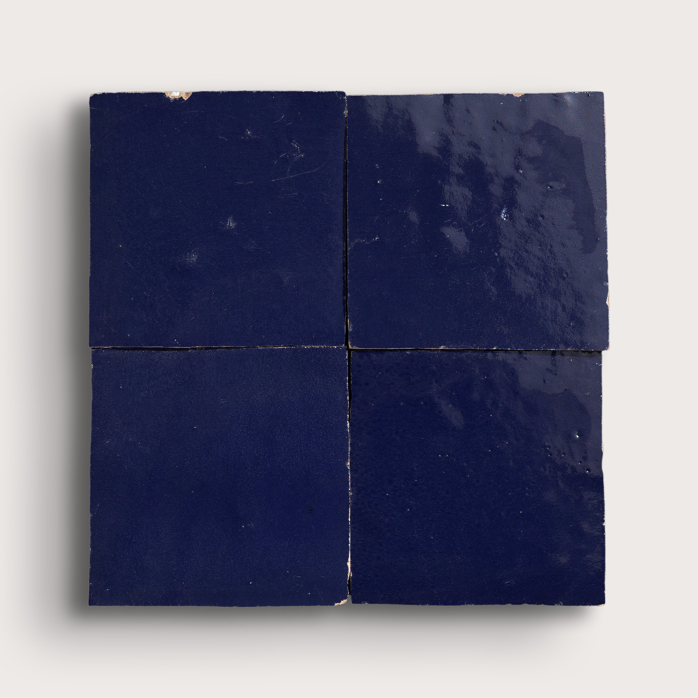 Four square blue zellige tiles on a white background