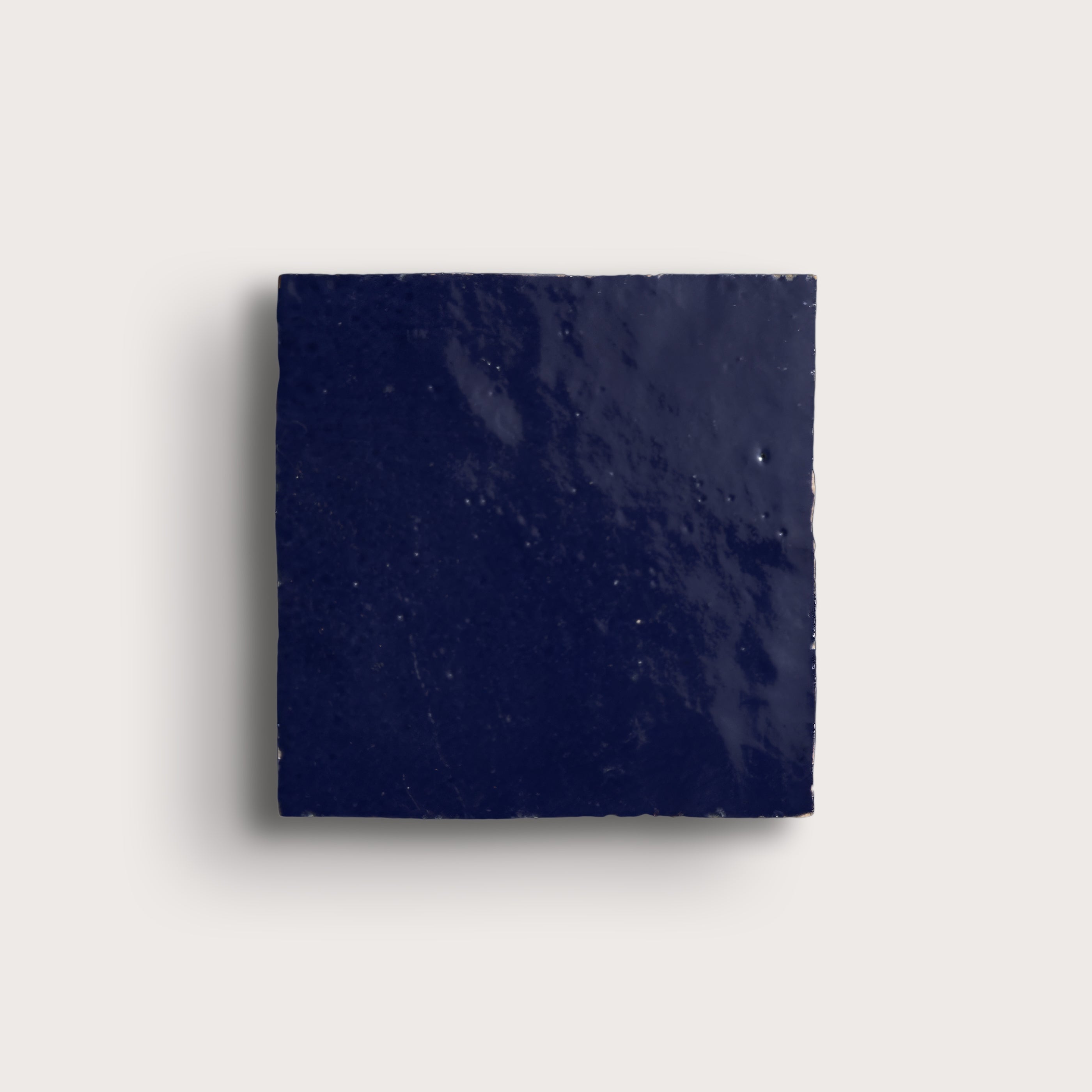 Navy blue square tile on a light gray background