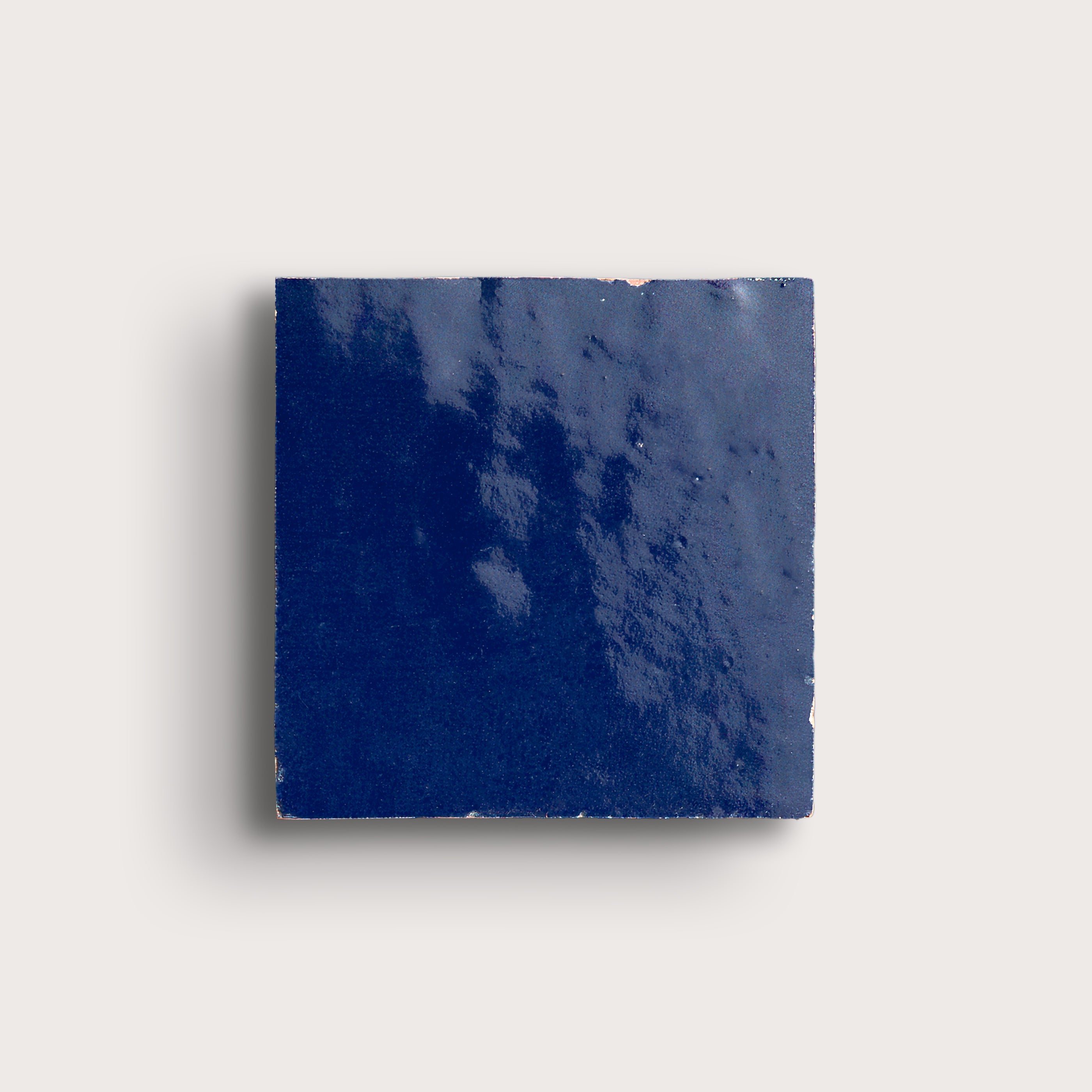 Square blue zellige tile on a light gray background