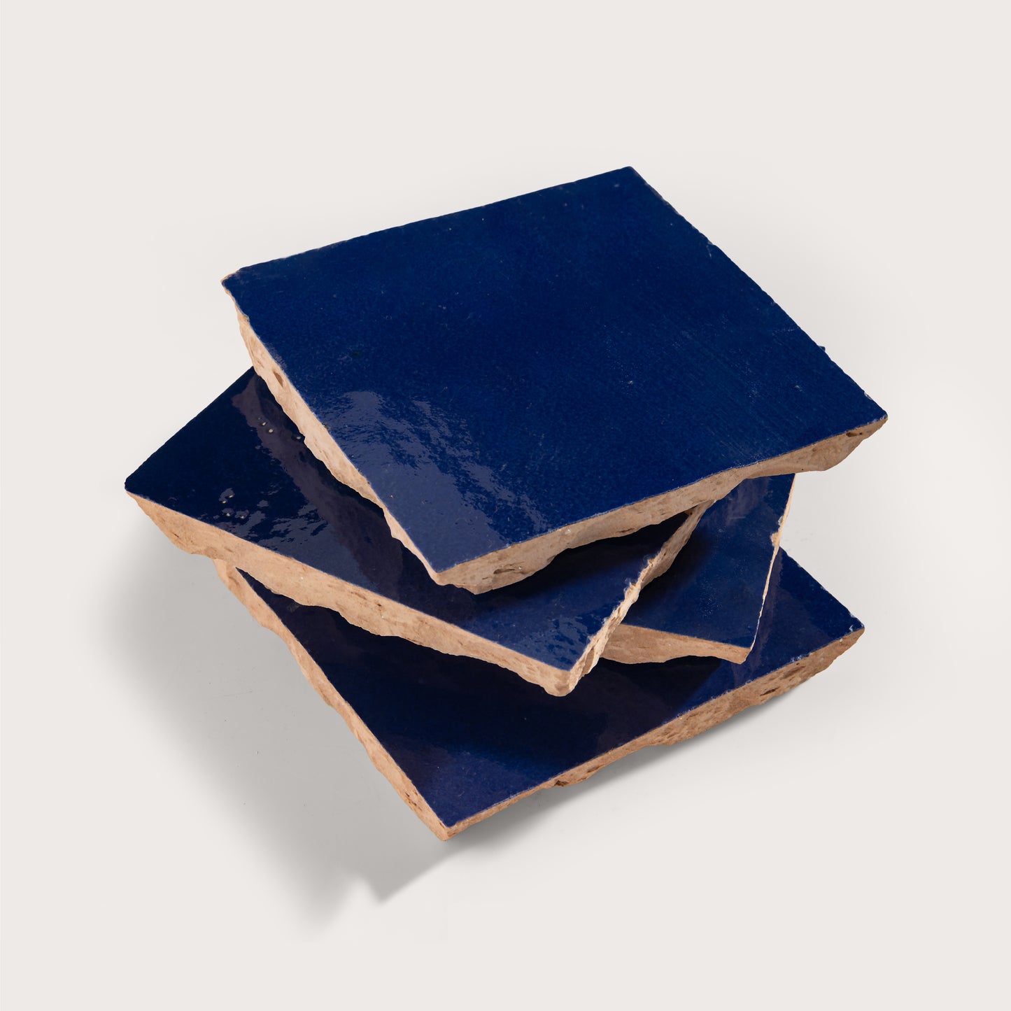 stack of blue square zellige tile on light grey background