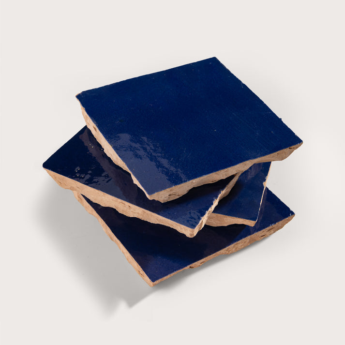 stack of blue square zellige tile on light grey background