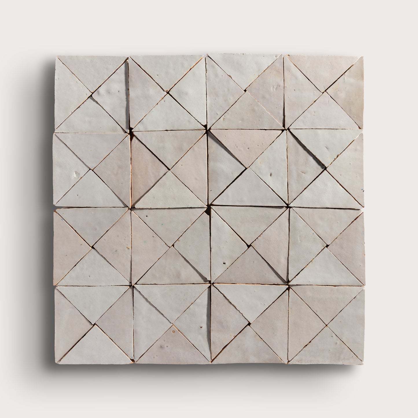 natural white mosaic triangle zellige tile on a light grey background
