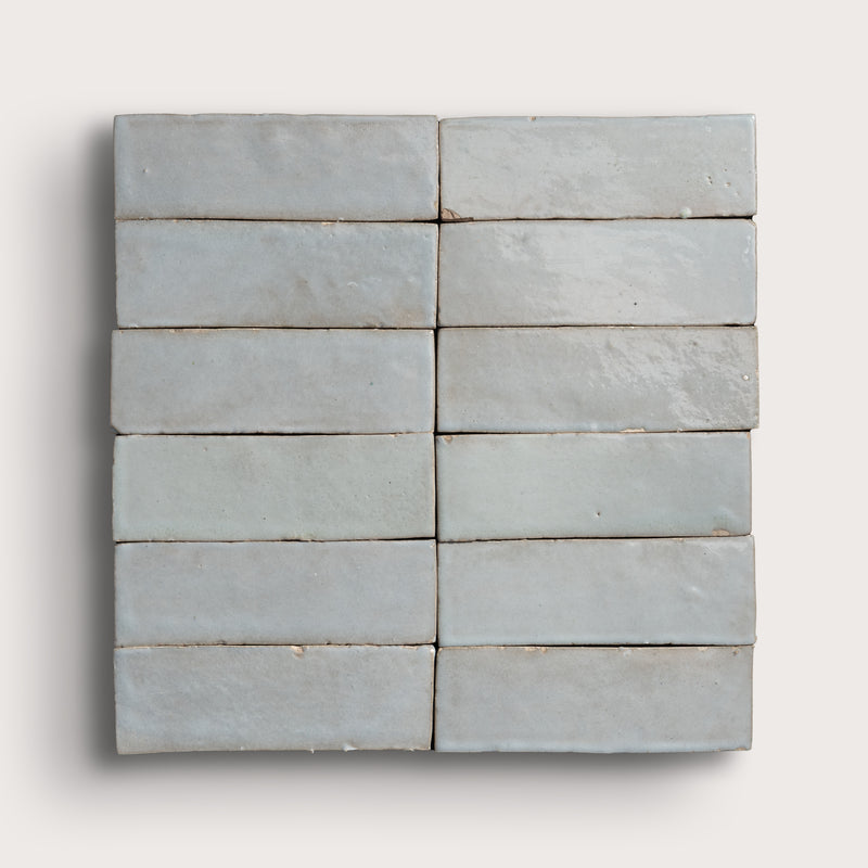 Set of gray rectangular zellige tiles arranged in a grid pattern on a white background