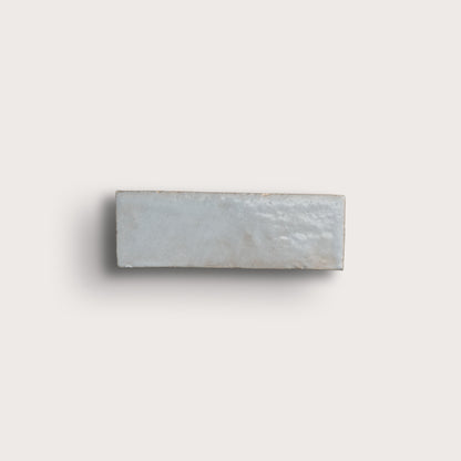 Rectangular zellige tile with a subtle pattern on a light gray background