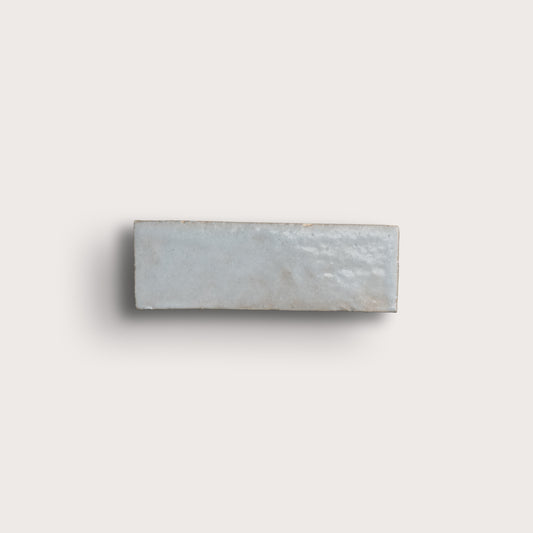 Rectangular zellige tile with a subtle pattern on a light gray background
