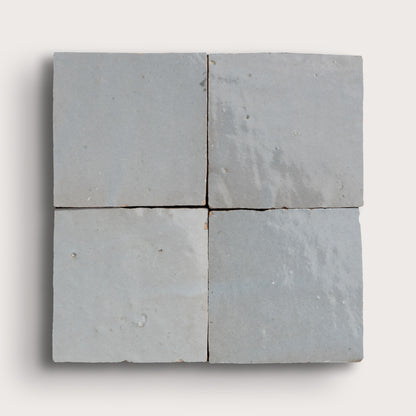 Four gray zellige tiles arranged in a 2x2 grid on a white background