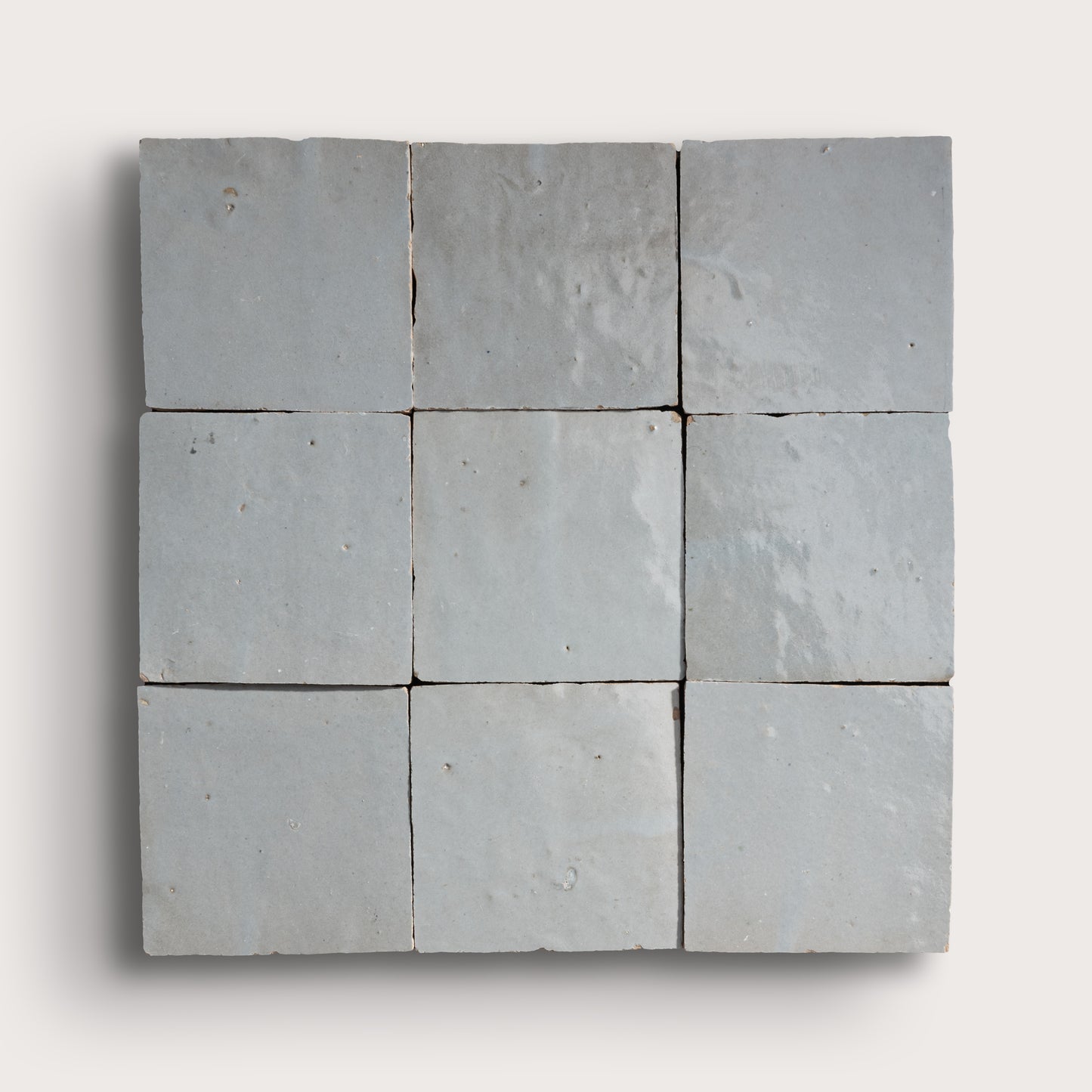 Nine square zellige stone tiles arranged in a 3x3 grid on a white background