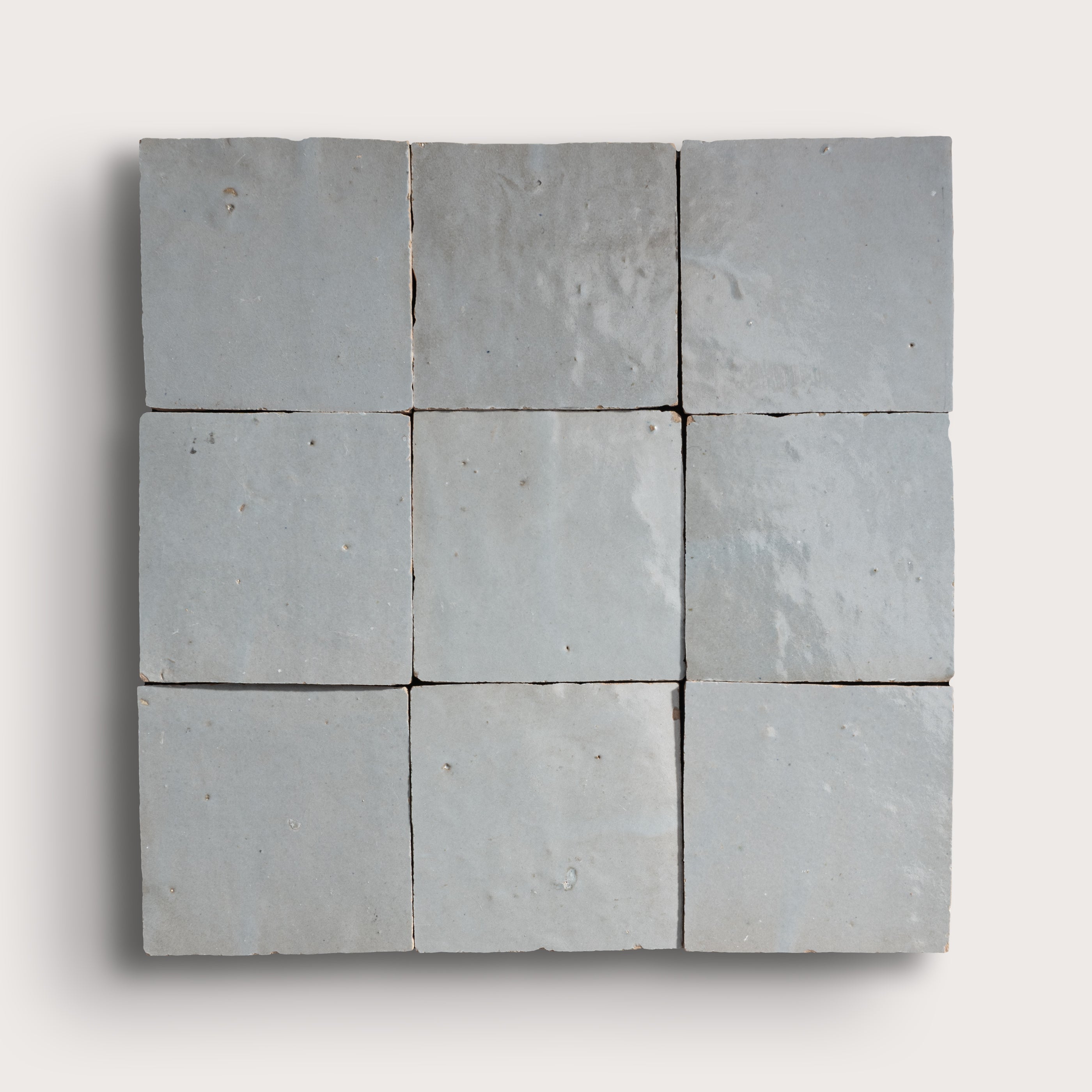Nine square zellige stone tiles arranged in a 3x3 grid on a white background