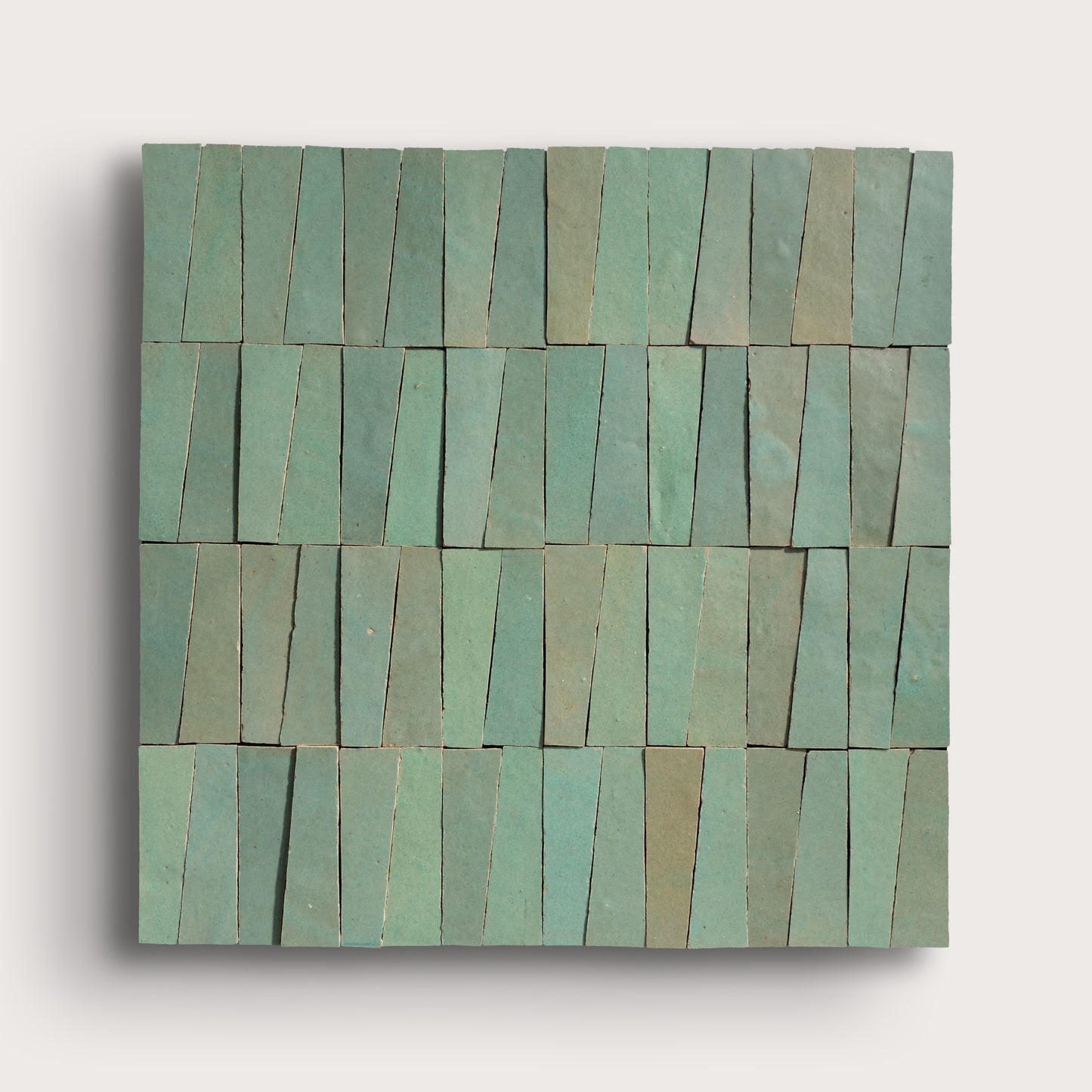 Rectangular green zellige tile with a pattern of horizontal stripes on a light gray background