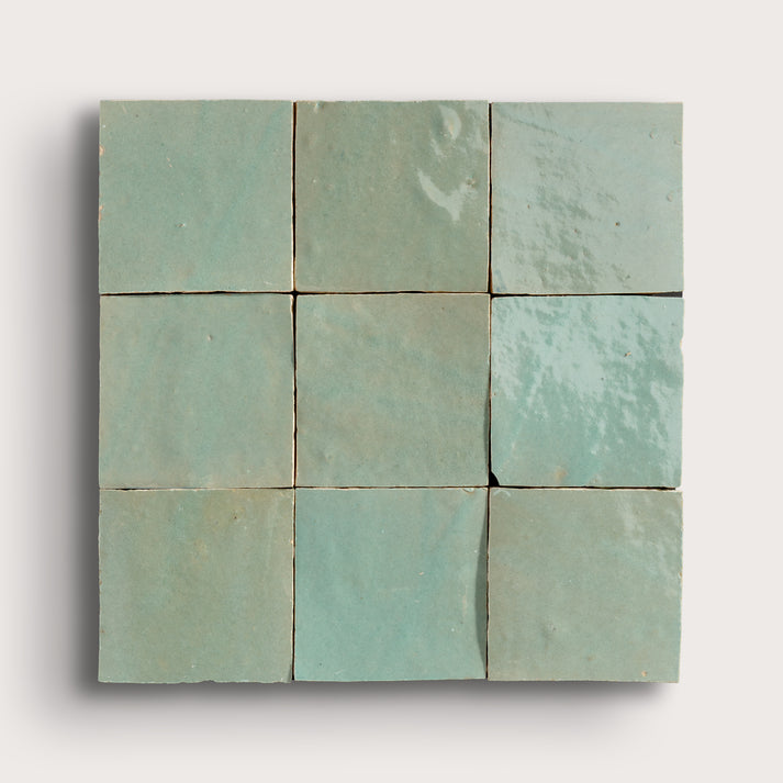 A 3x3 grid of square zellige tiles in a light mint green glaze, arranged in a square block with a subtle drop shadow on a light gray background.