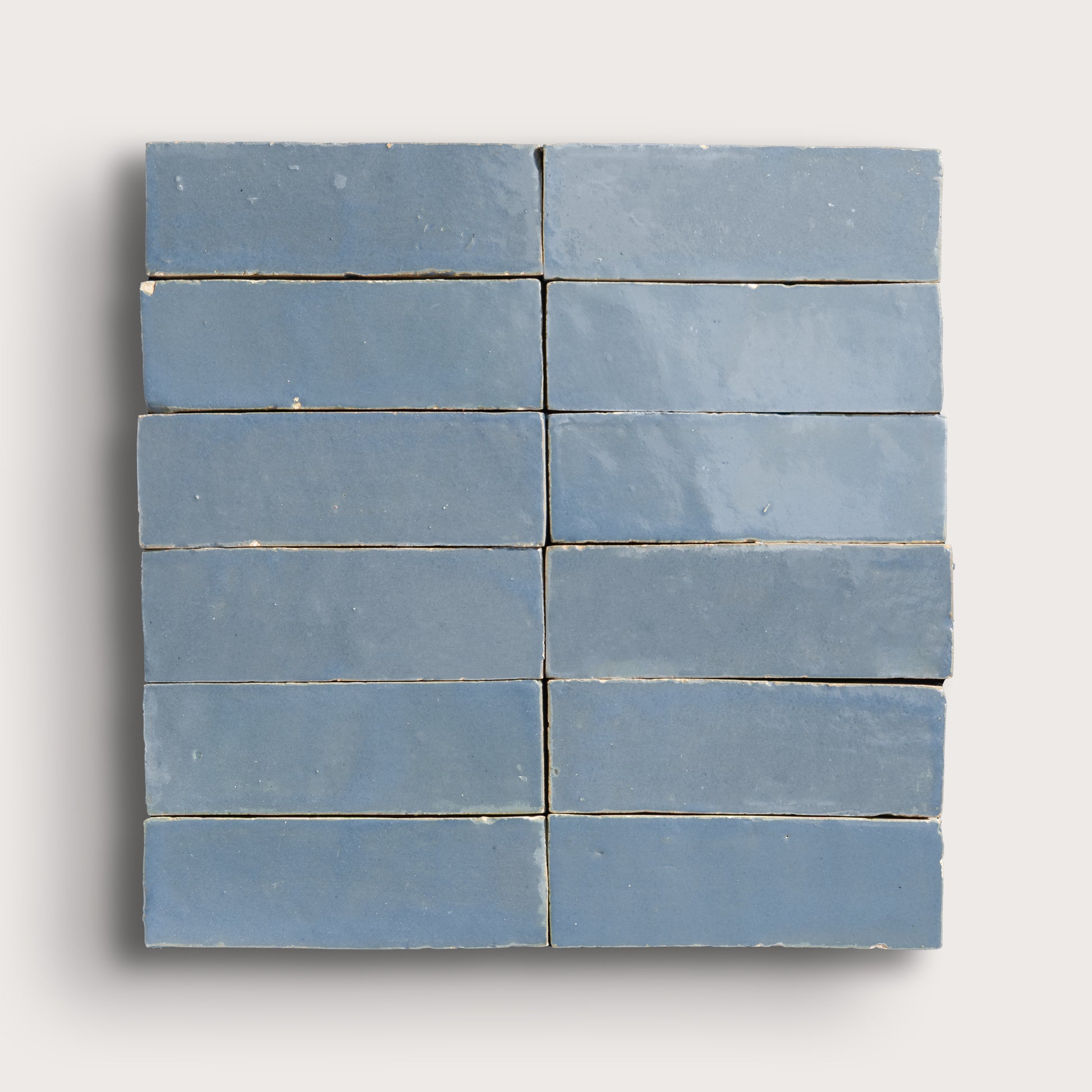Blue zellige tiles arranged in a grid pattern on a white background