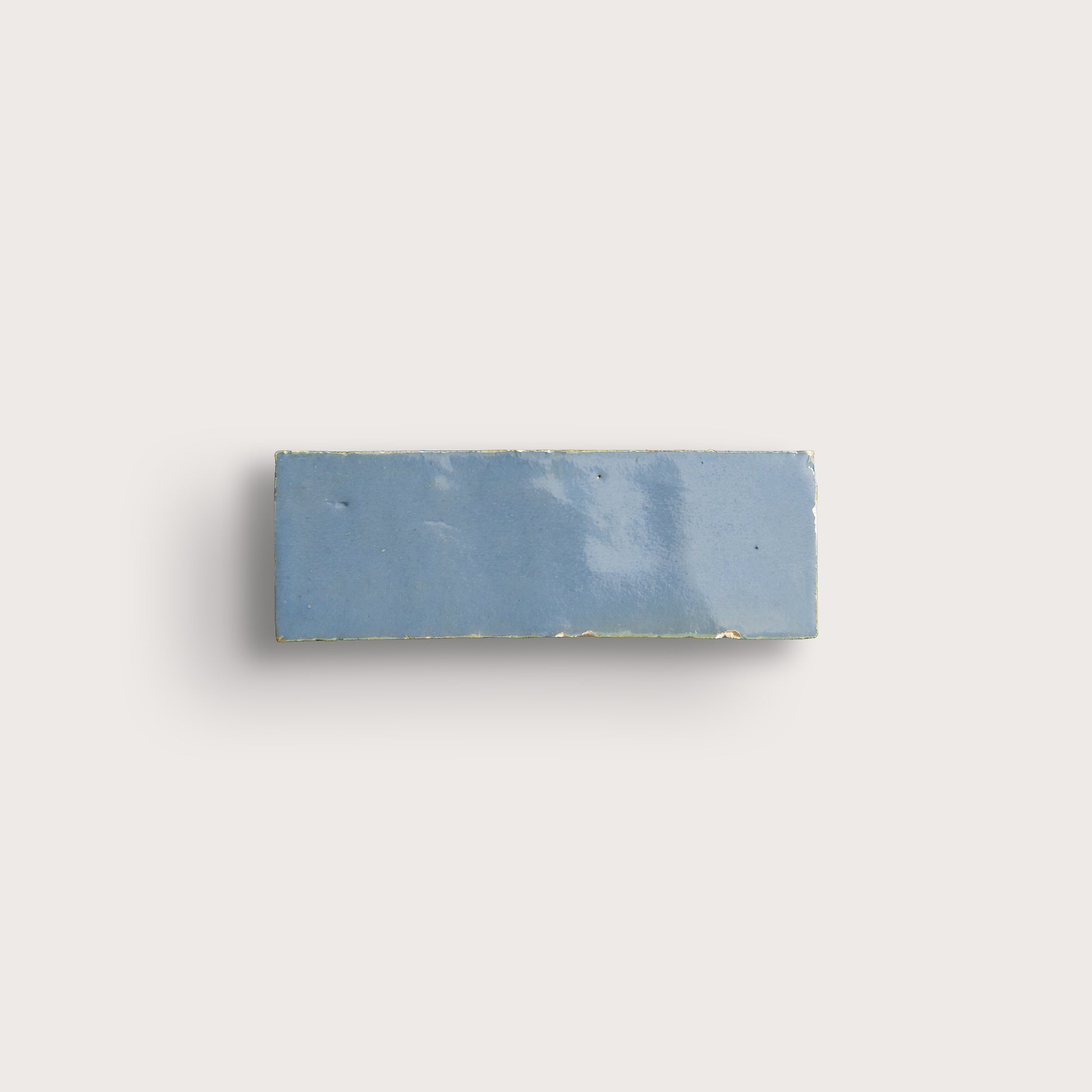 Rectangular blue tile on a light gray background
