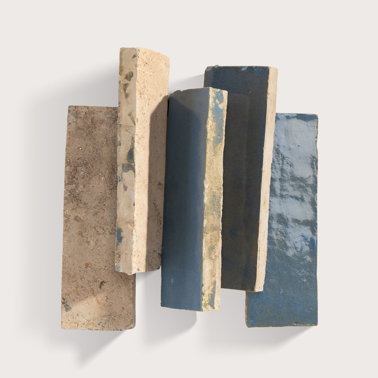 Set of five rectangular zellige stone tiles with varying textures and colors on a white background