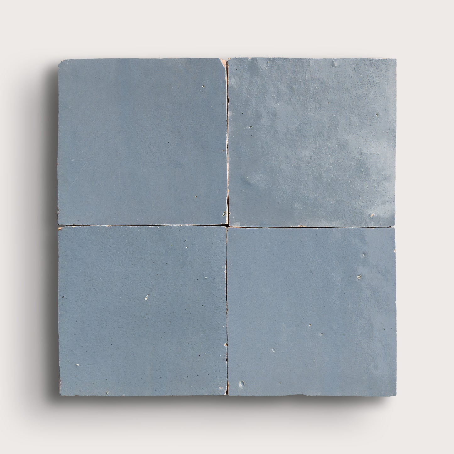 Four square blue zellige tiles on a white background