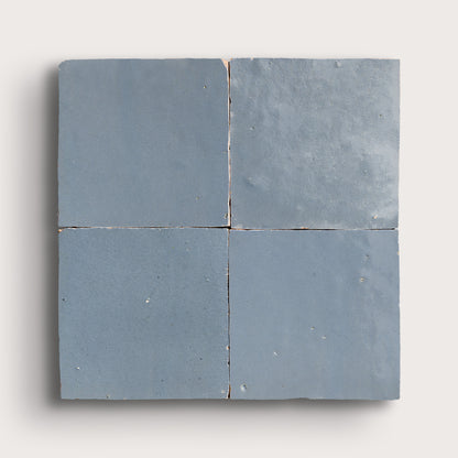 Four square blue zellige tiles on a white background