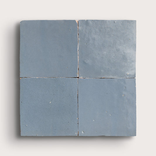 Four square blue zellige tiles on a white background