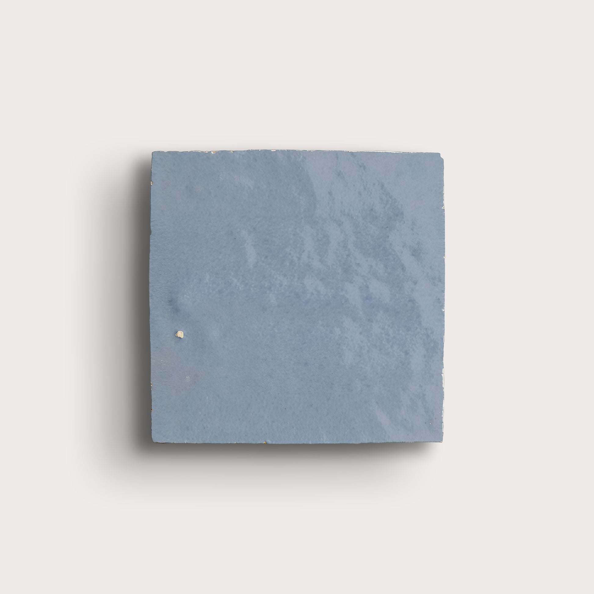 Square zellige blue tile on a light gray background