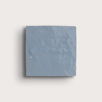Square zellige blue tile on a light gray background