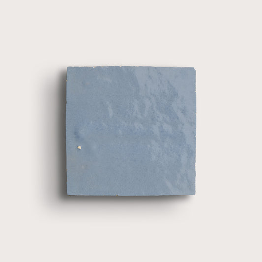Square zellige blue tile on a light gray background