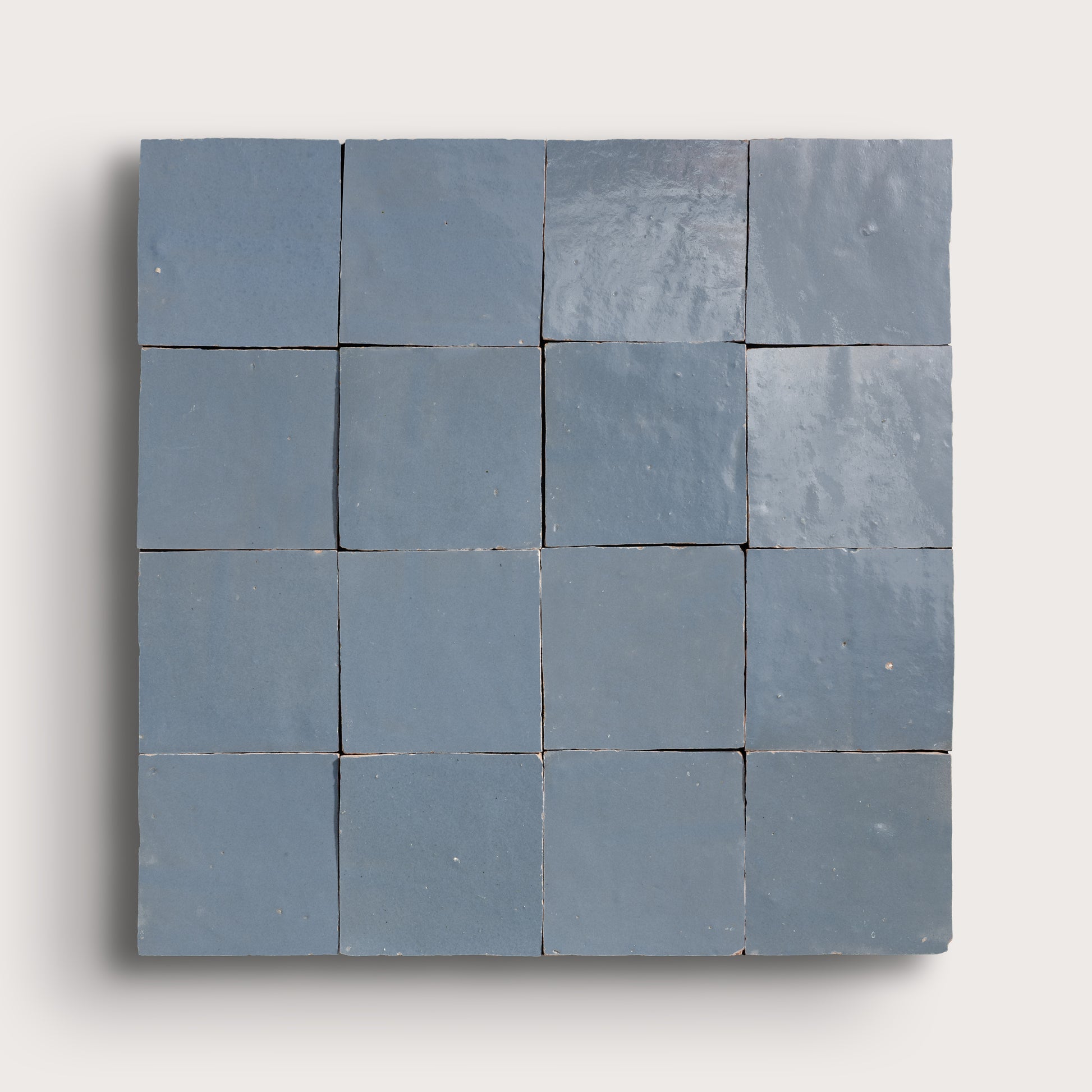 Square arrangement of blue zellige tiles on a white background