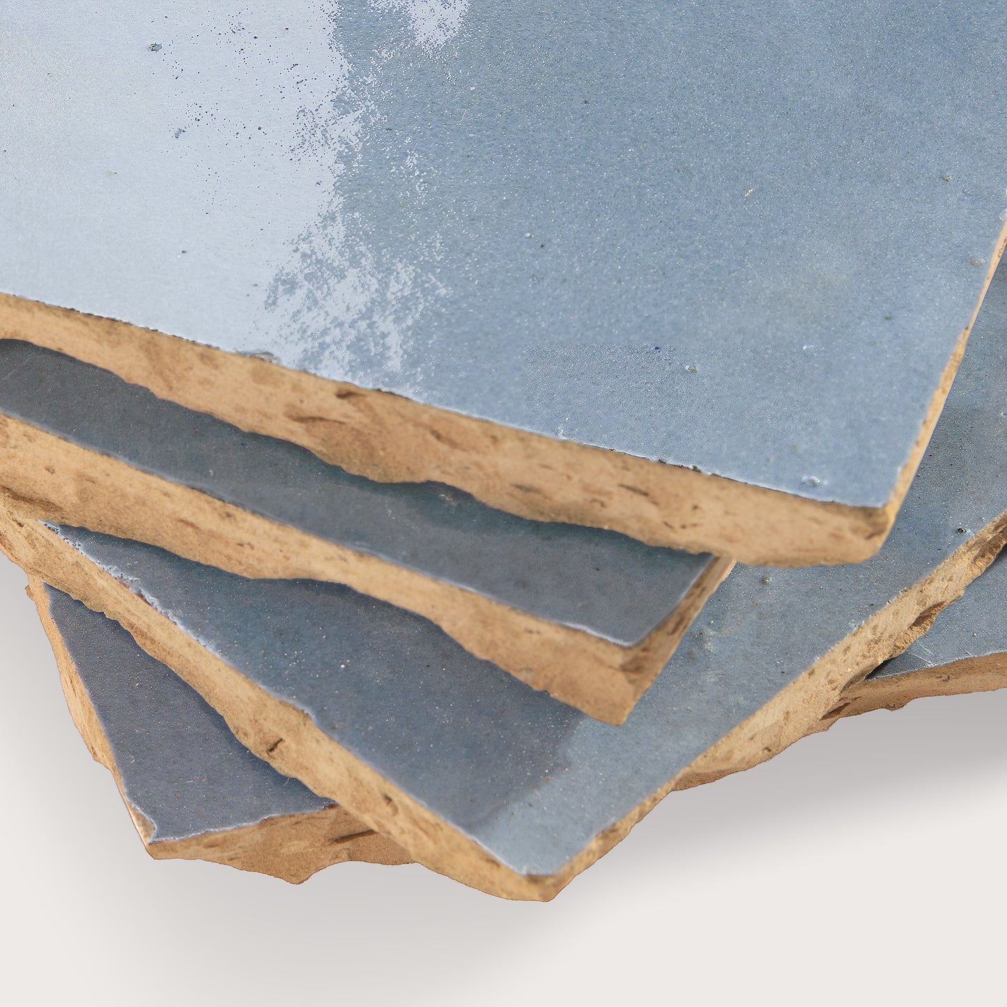 Close-up of zellige tile with a blue glaze on a white background