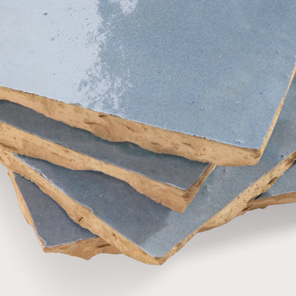 Close-up of zellige tile with a blue glaze on a white background
