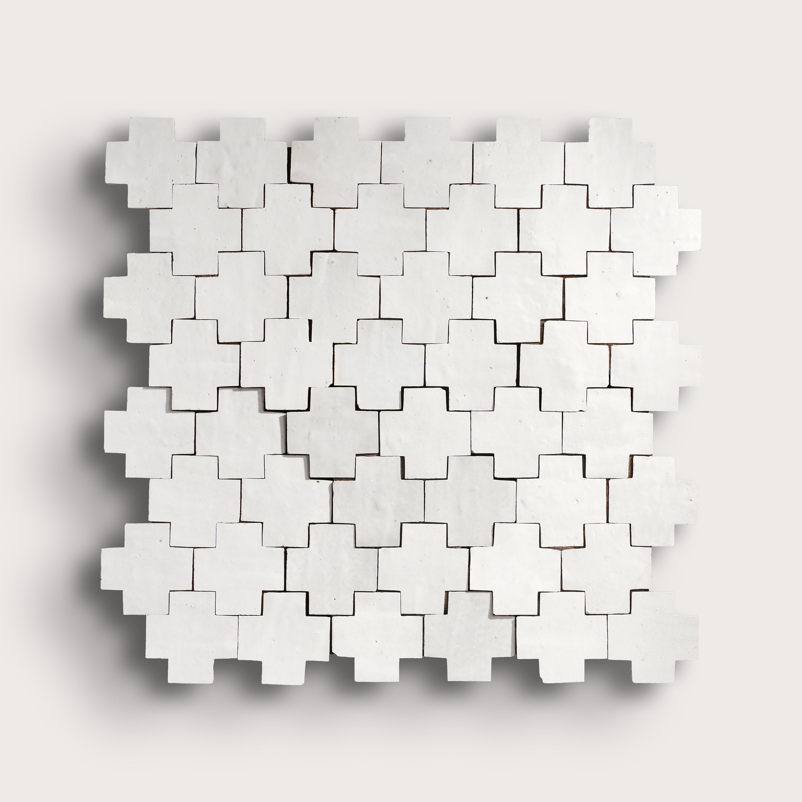 white zellige tile with geometric design on a white background