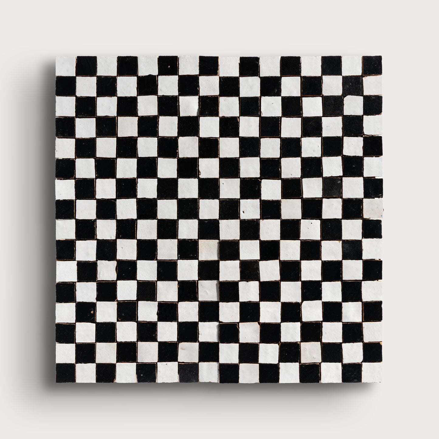 black and white small square checkerboard zellige tile on a light grey background