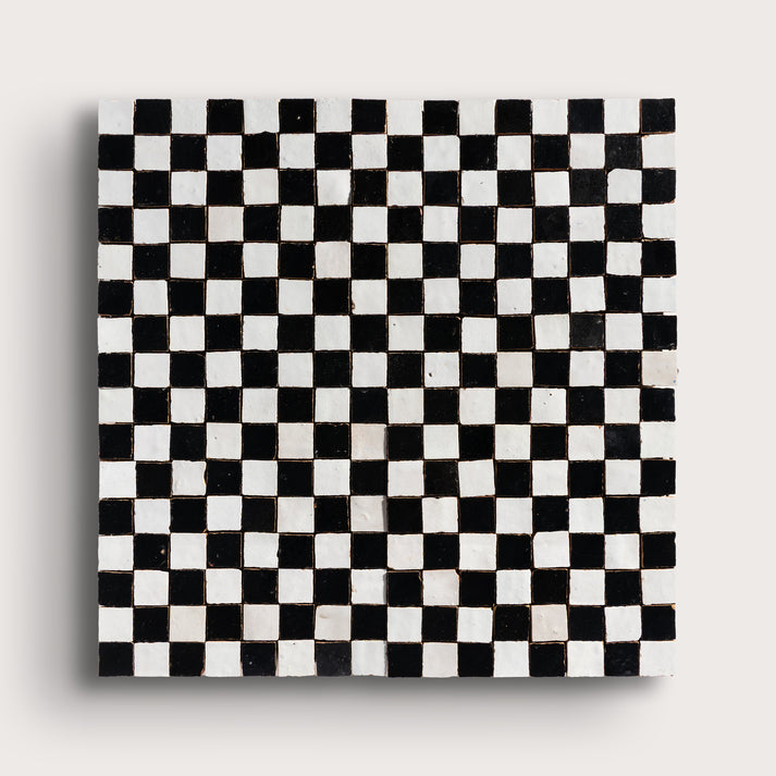 black and white small square checkerboard zellige tile on a light grey background