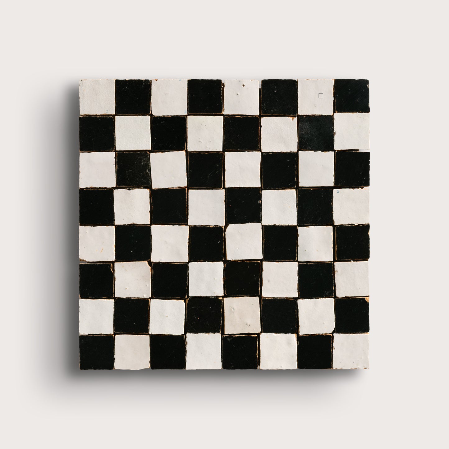 black and white small square checkerboard zellige tile on a light grey background