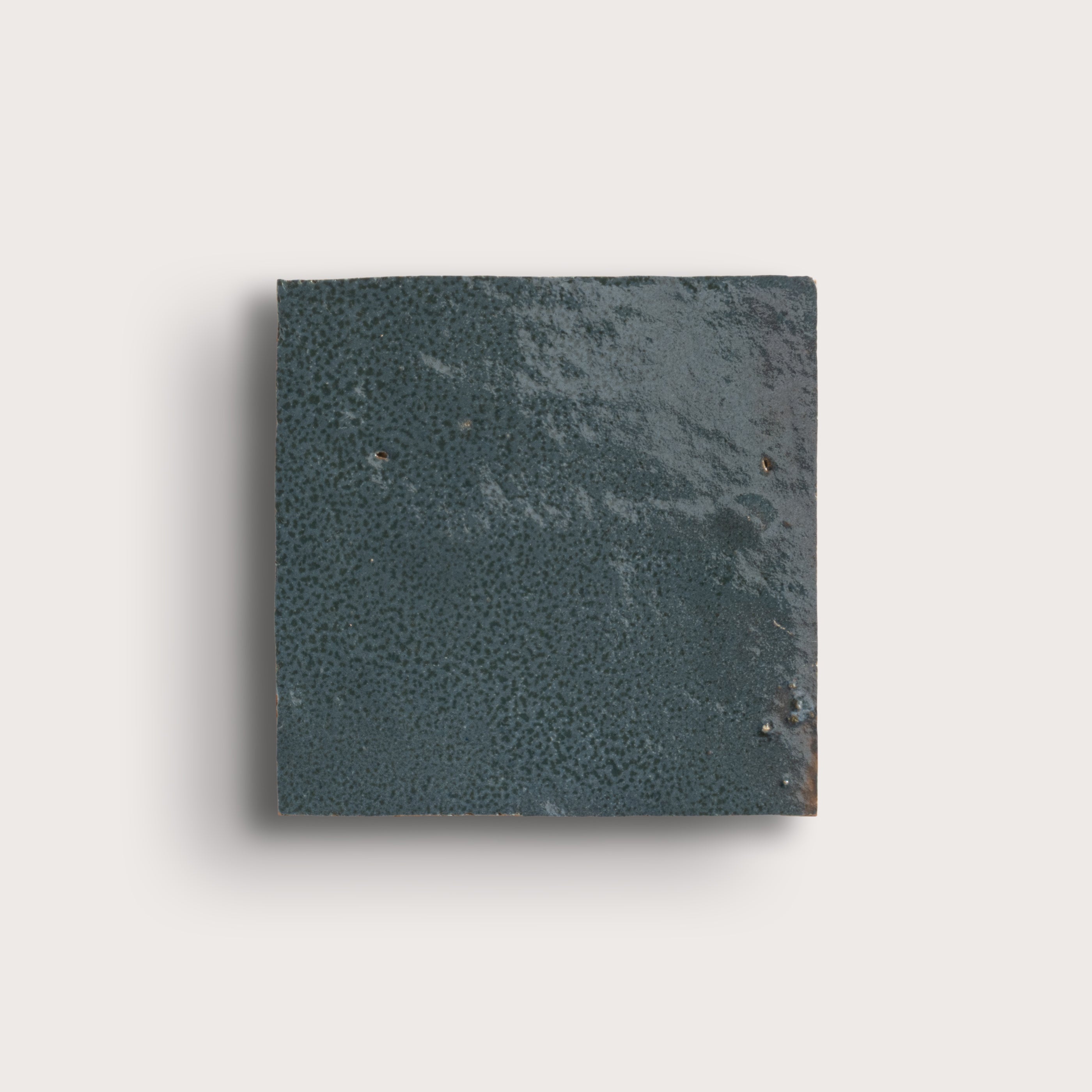 Square dark gray stone tile on a light gray background