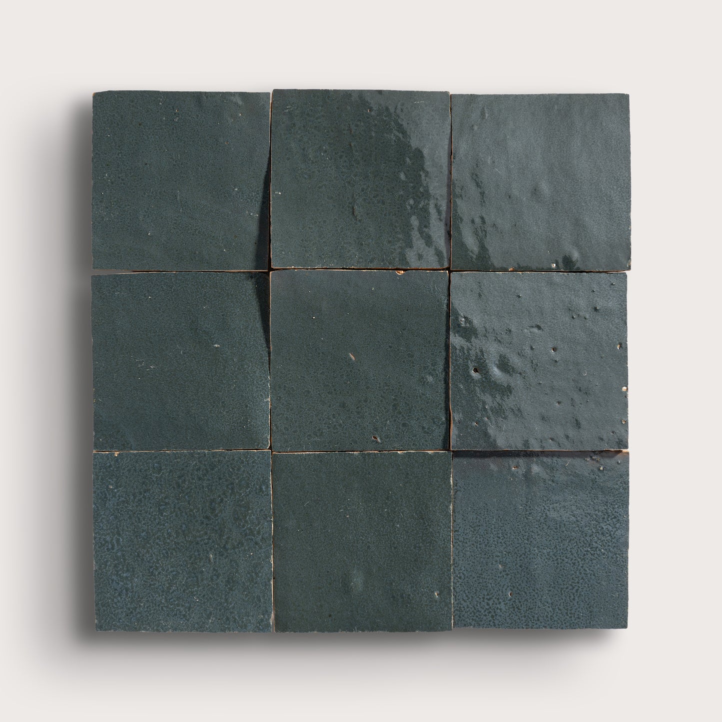 Nine grey zellige square tiles arranged in a 3x3 grid on a white background