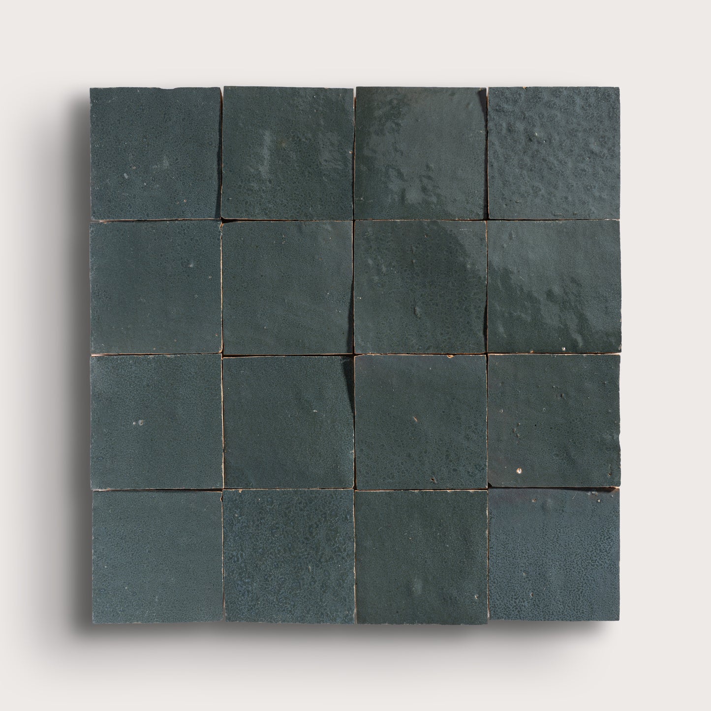 Square arrangement of grey zellige tiles on a white background