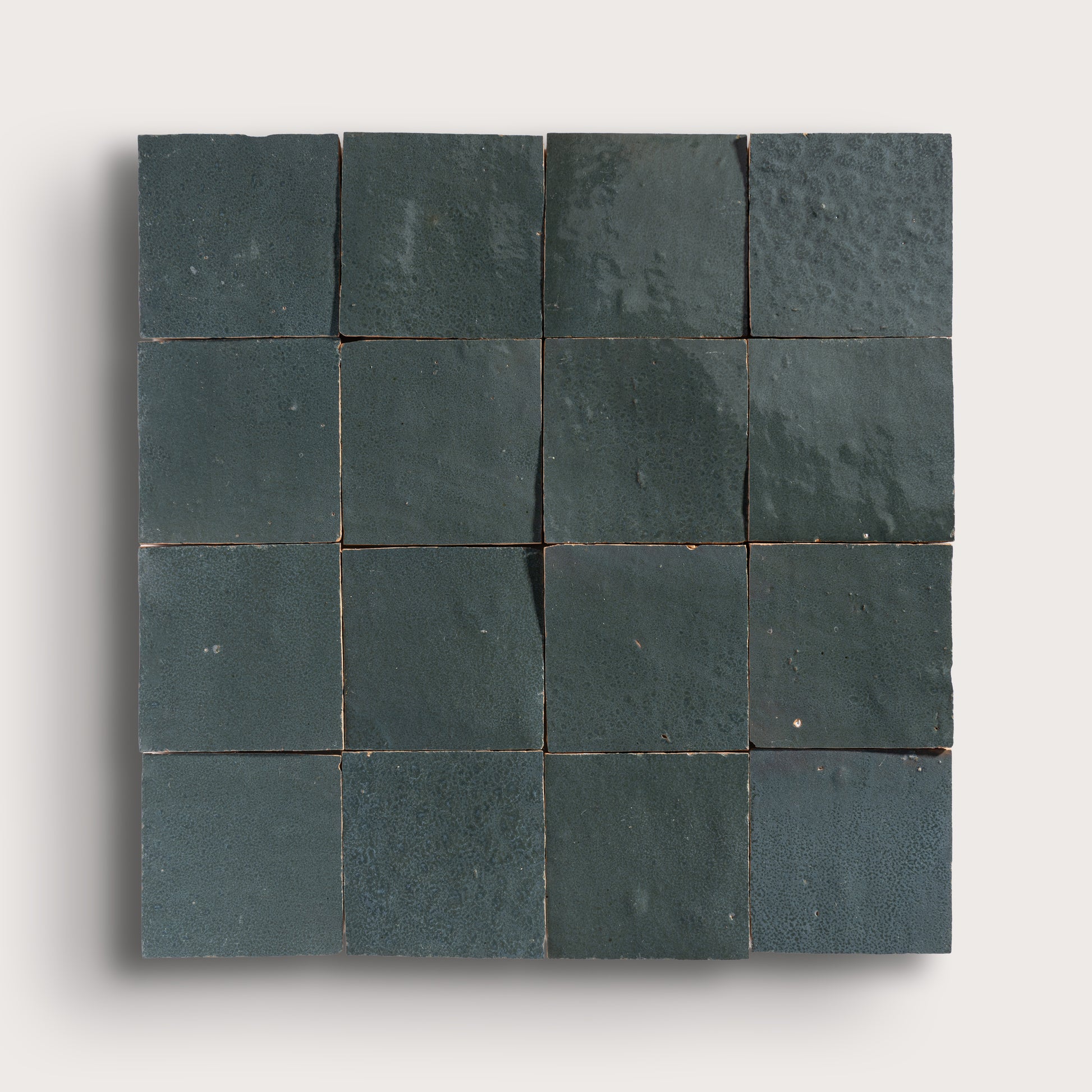 Square arrangement of grey zellige tiles on a white background