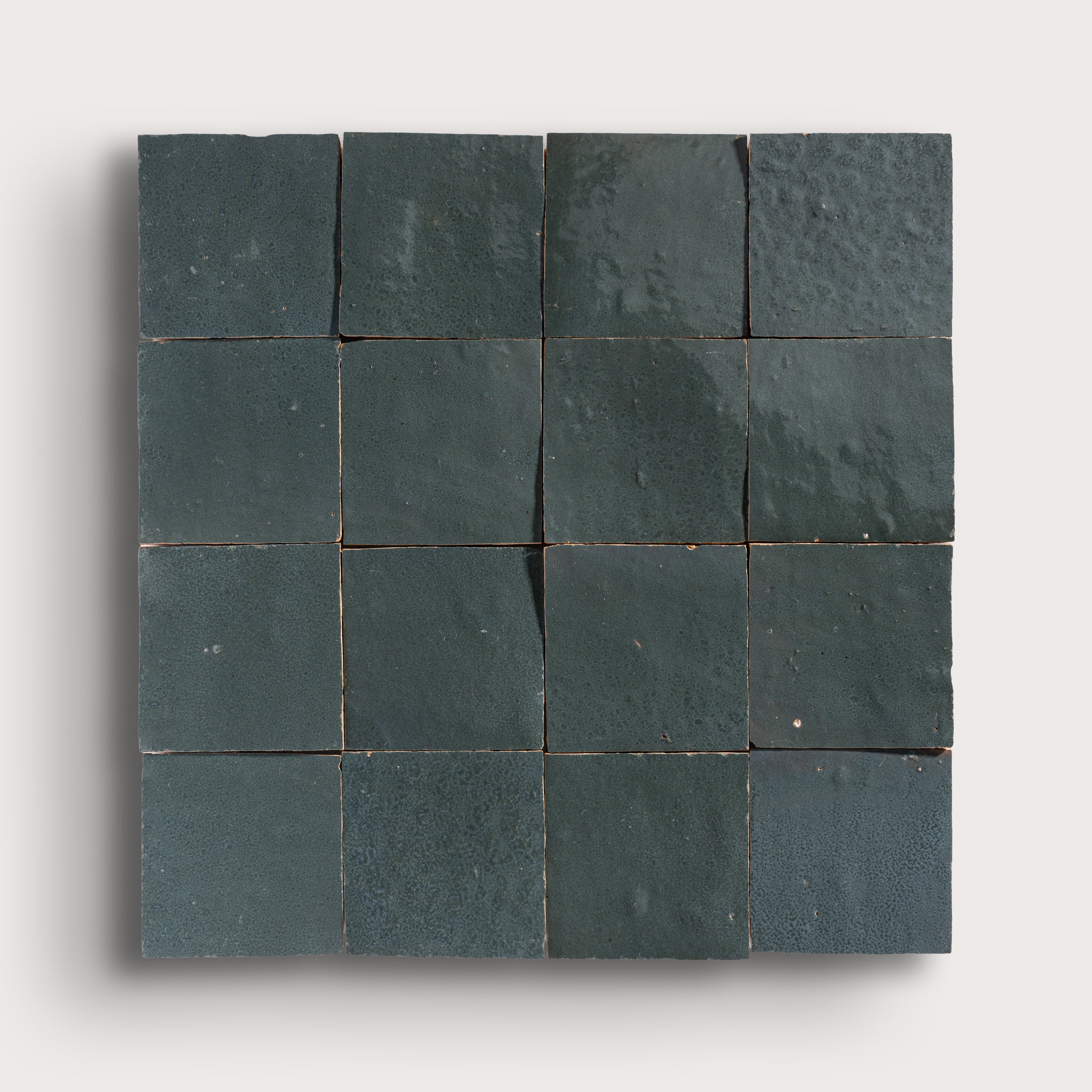 Square arrangement of grey zellige tiles on a white background