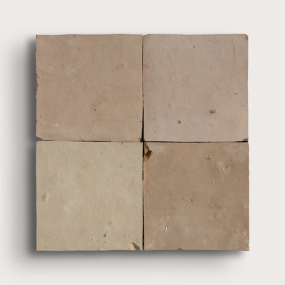 Four square zellige tiles arranged in a 2x2 grid, showcasing four different earthy tones from beige to light brown, set against a clean off-white background with a soft drop shadow.