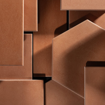 Close-up of geometric terracotta tiles, arranged in an abstract layered composition.