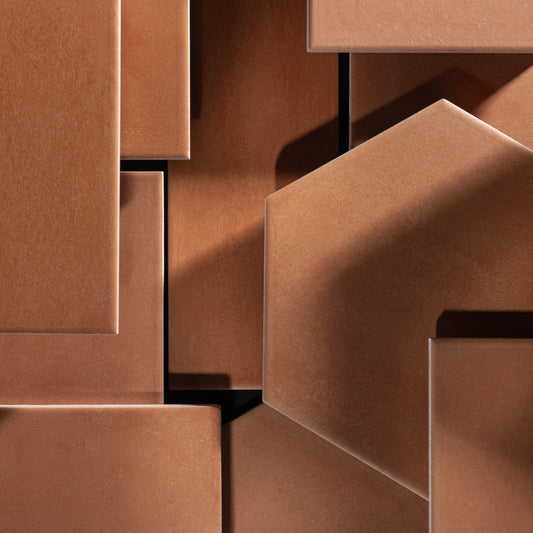 Close-up of geometric terracotta tiles, arranged in an abstract layered composition.