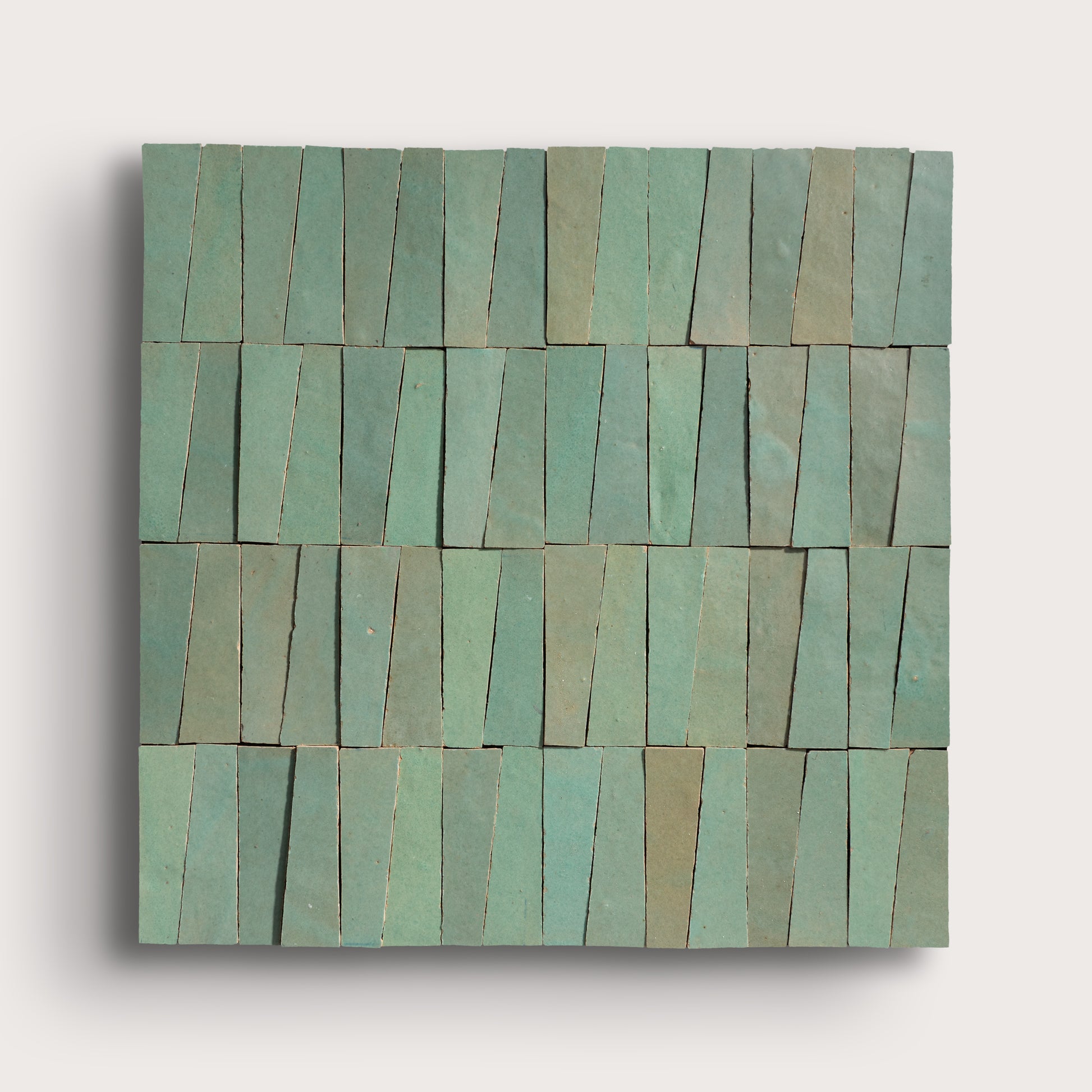 Rectangular green zellige tile with a pattern of horizontal stripes on a light gray background
