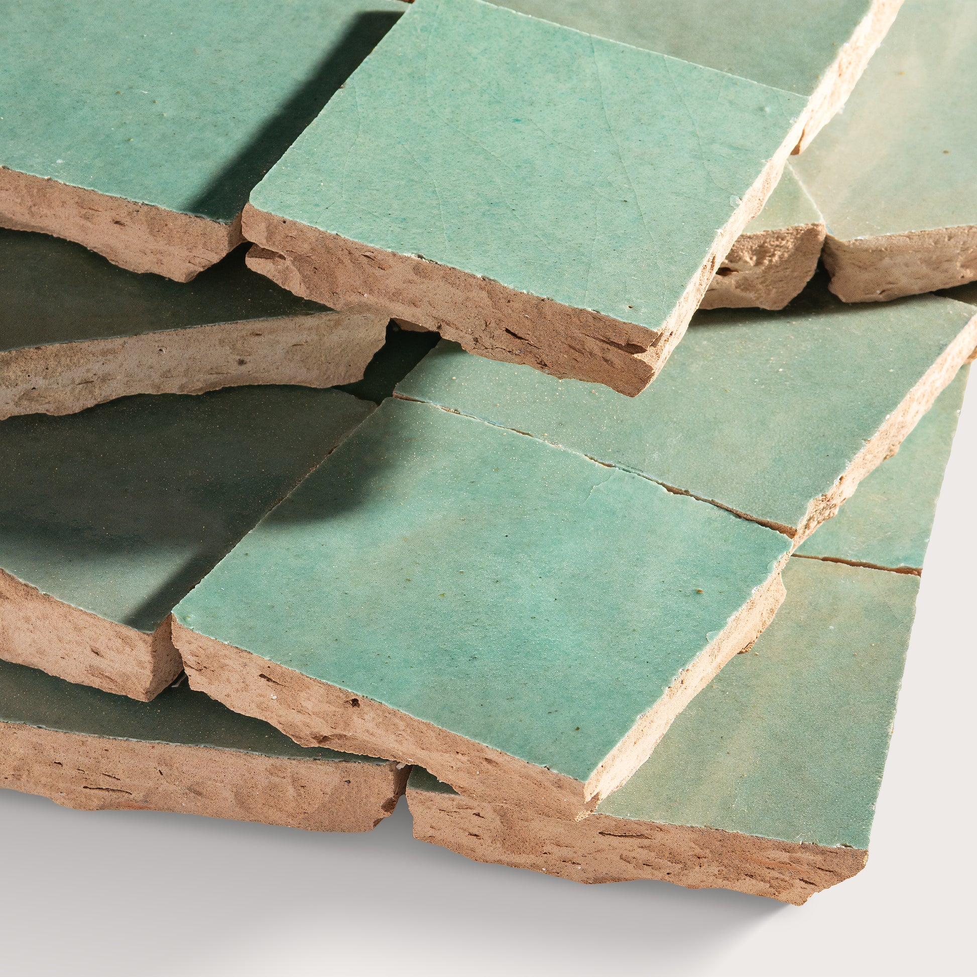 Stack of green zellige tile on a white background
